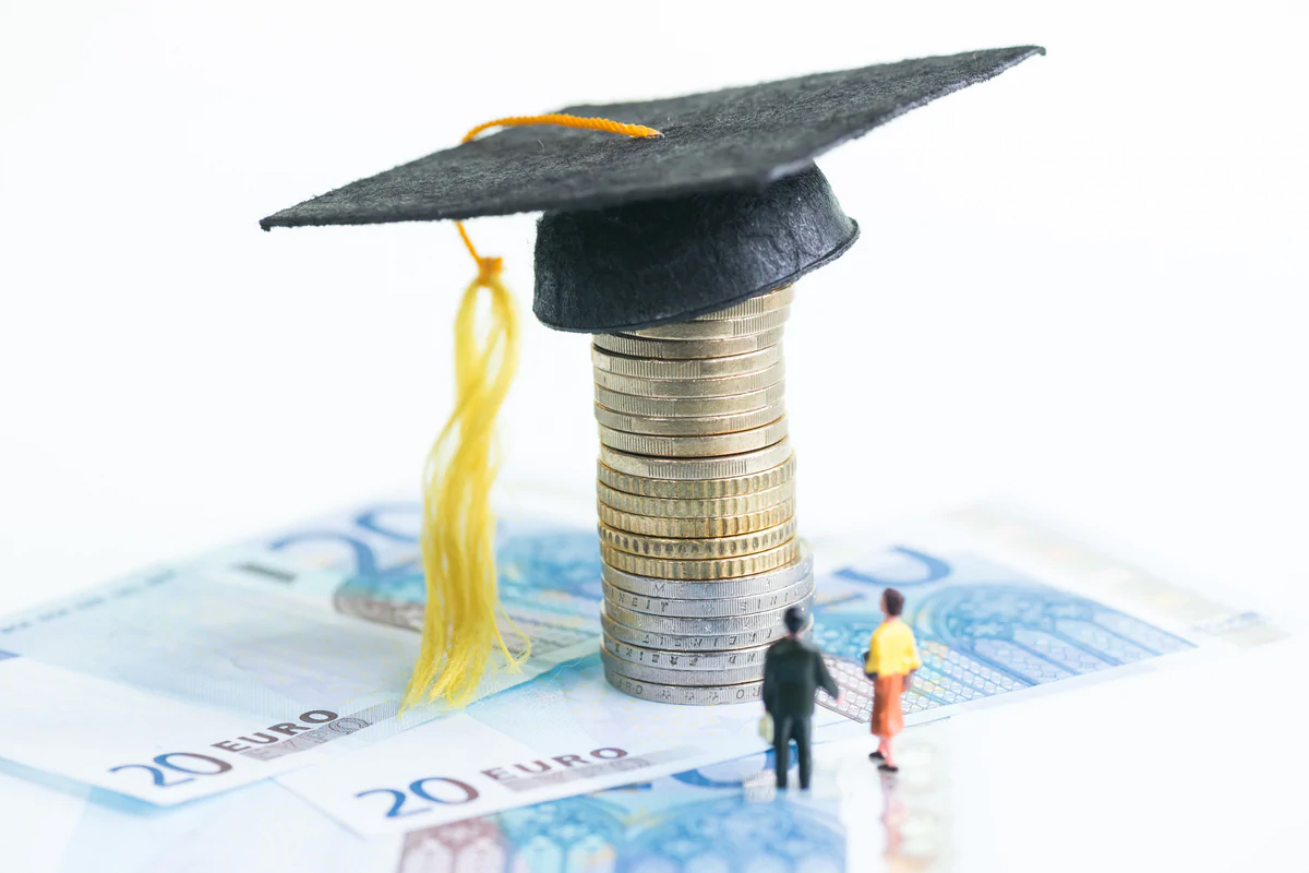 Tocco universitario su pila di monete e banconote da 20 euro