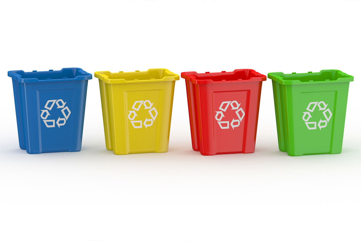 quattro contenitori di colori diversi con in simbolo del riciclo sulla parte frontale