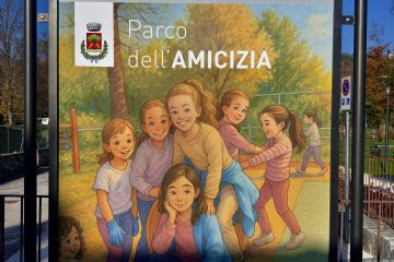 Cartello del Parco giochi inclusivo con nome "Parco dell'Amicizia" e immagine di bambini che giocano effetto cartone animato